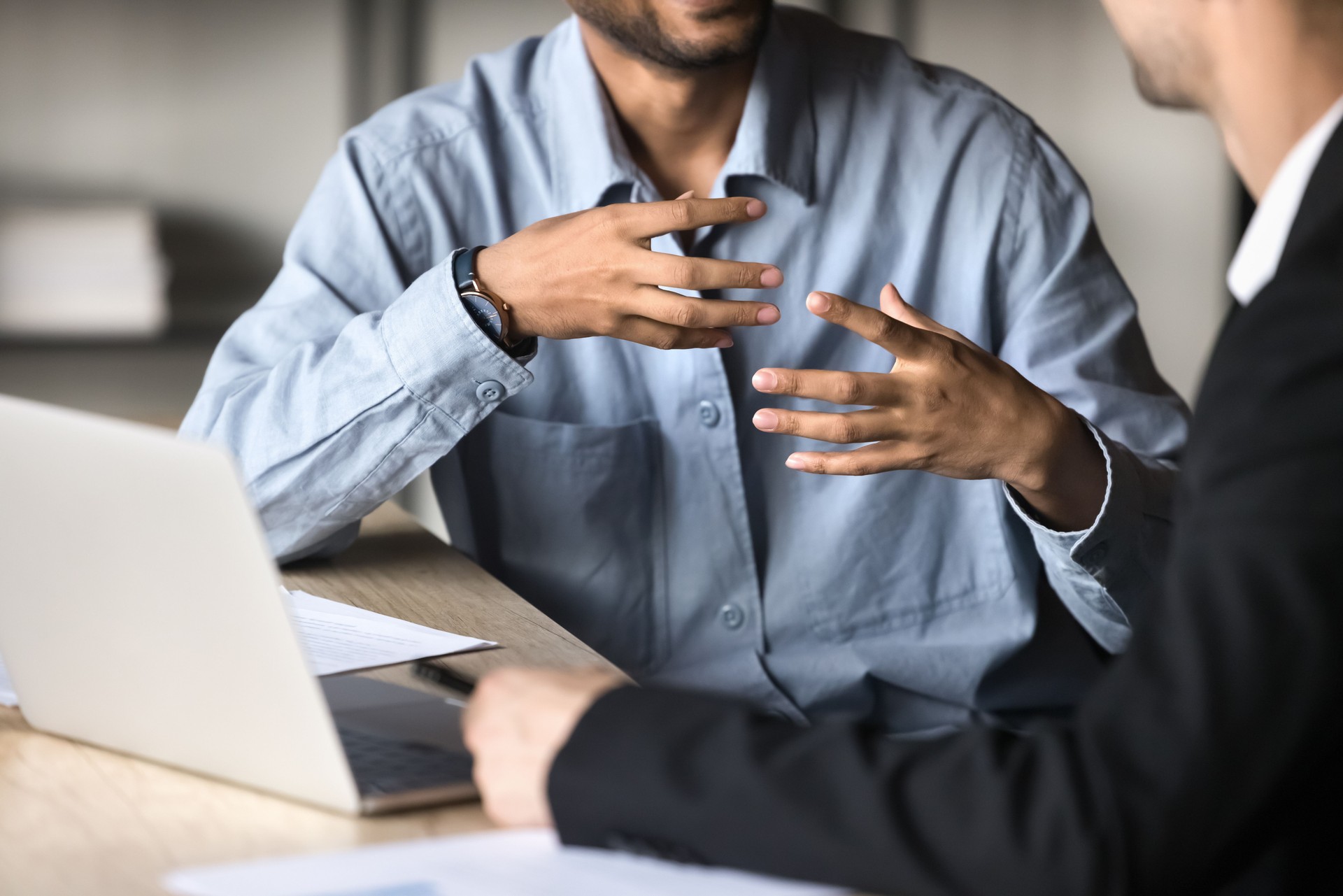 Two male colleagues engaged in discussion, close up cropped view